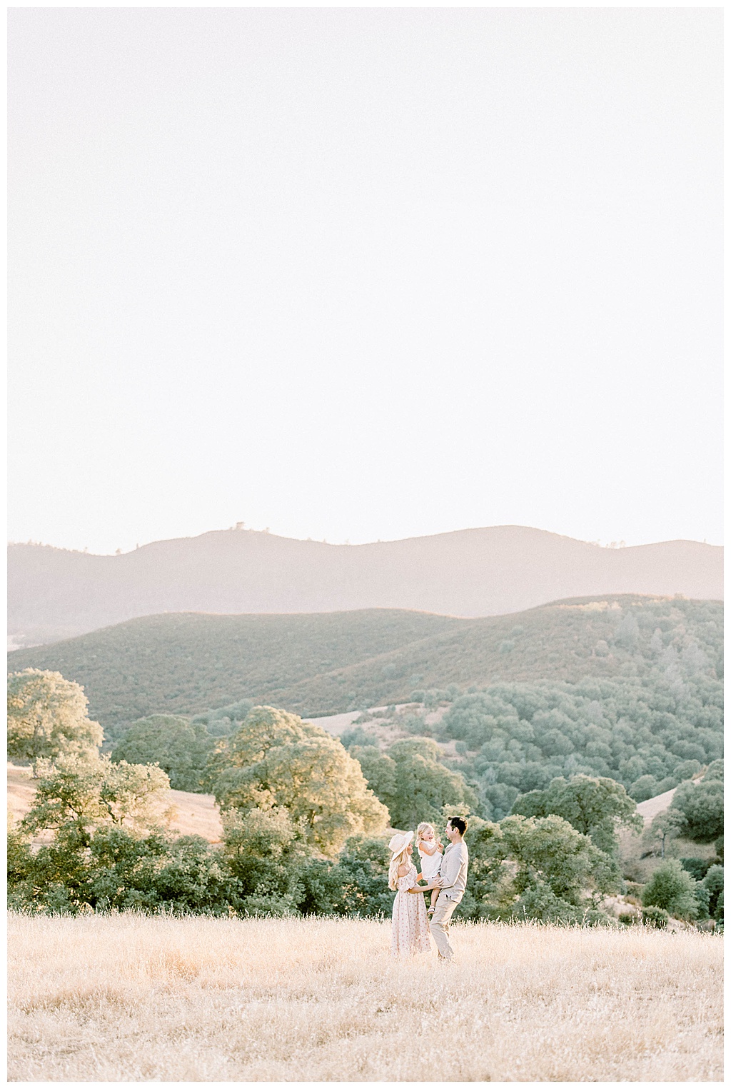 Sacramento Family photographer with an image in the mountains of a mom, daughter, and dad tinted in the most beautiful pink by Shan Cait Photography.